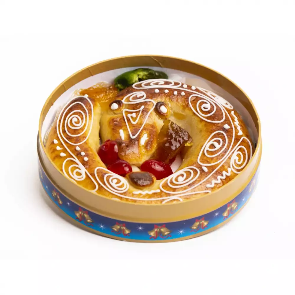 Anguila de mazapán decoradas con glaseado blanco y cerezas, presentadas en una caja de metal azul.